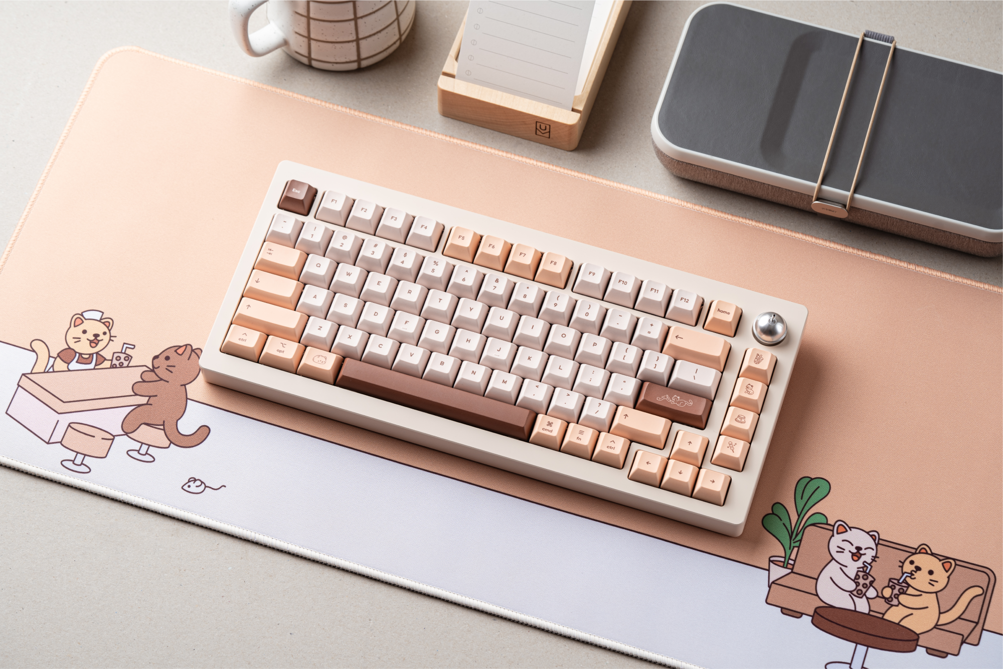 an angled birds-eye shot of Sprout 75 laying on the brown sugar boba deskpad. towards the upper edge of the image there's a white mug with a grid pattern, and a wooden to-do organizer with a card in it.