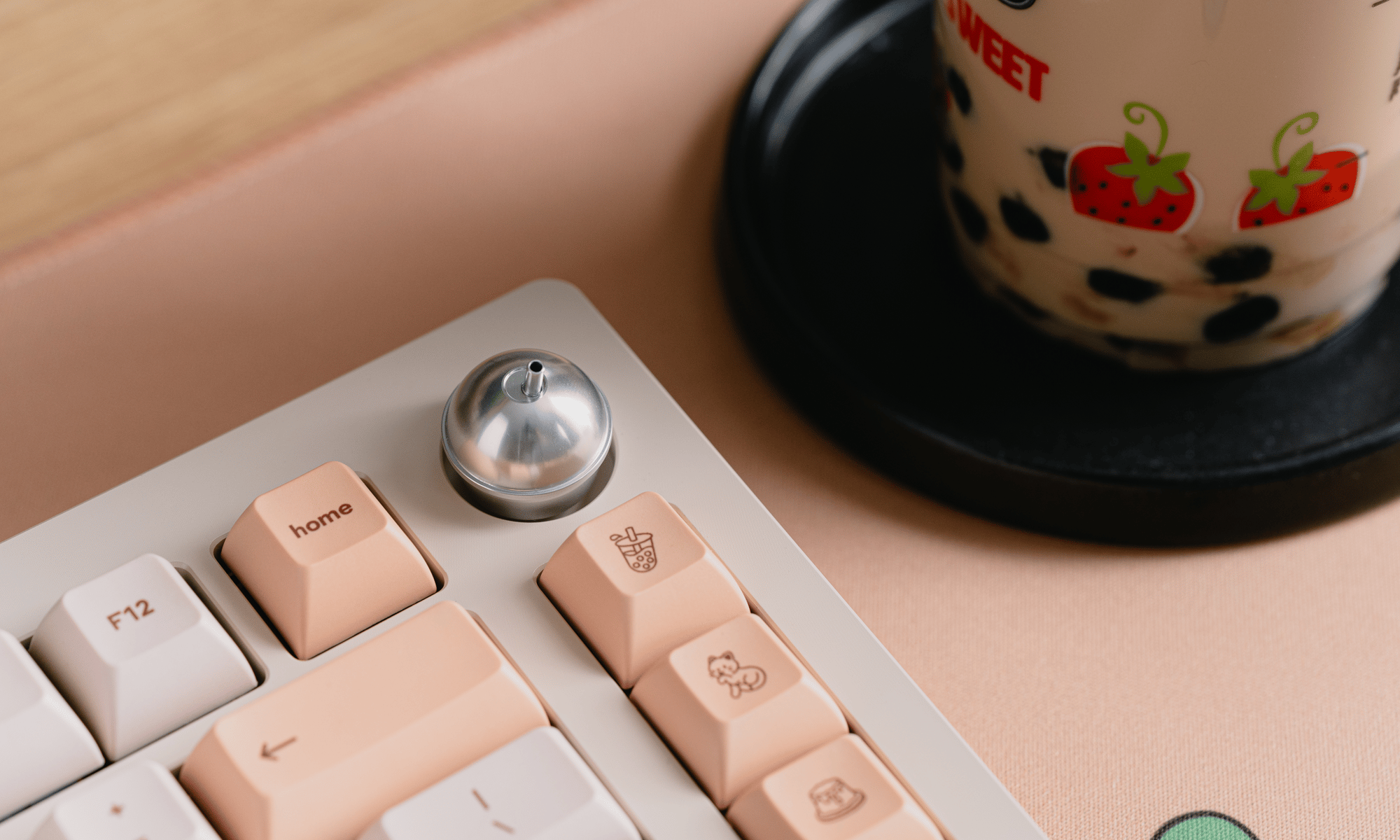 a close-up of the Sprout 75 knob, also showing the keys next to and below it. to the side, cut off, is a cup of bubble tea.